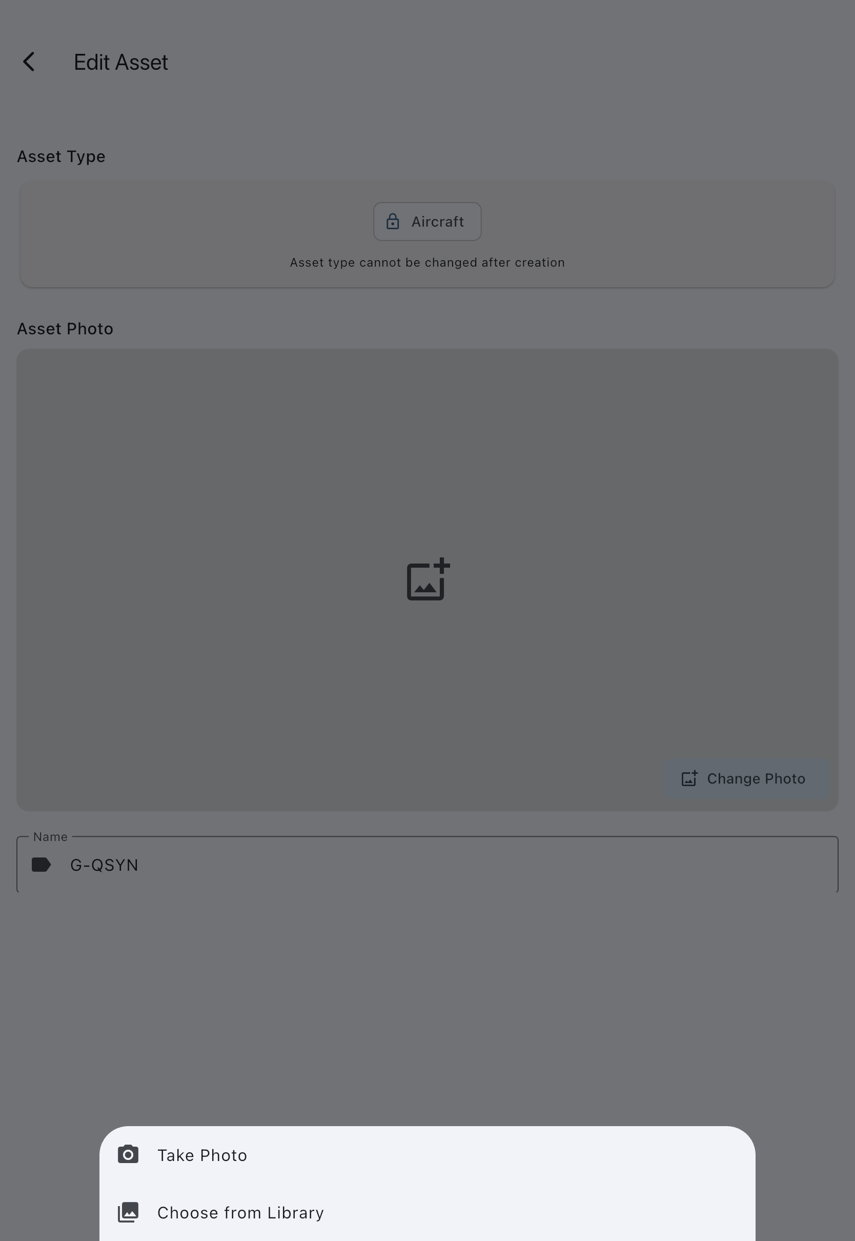 The Edit Asset screen with the Asset Photo section near the top, its Change Photo button, and the source picker offering the camera or the photo library